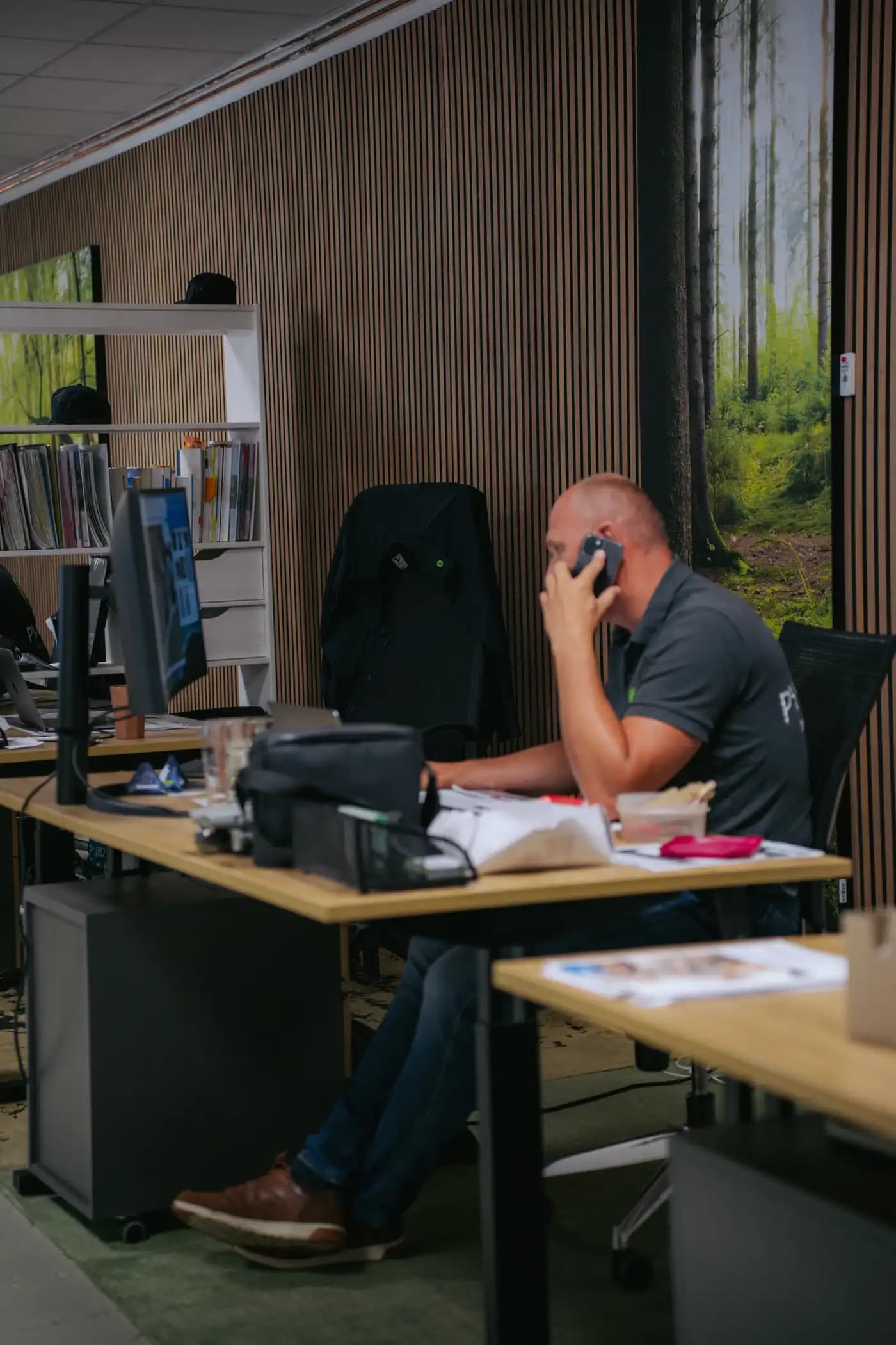 Mitarbeiter verhandelt telefonisch am Schreibtisch der Zentrale